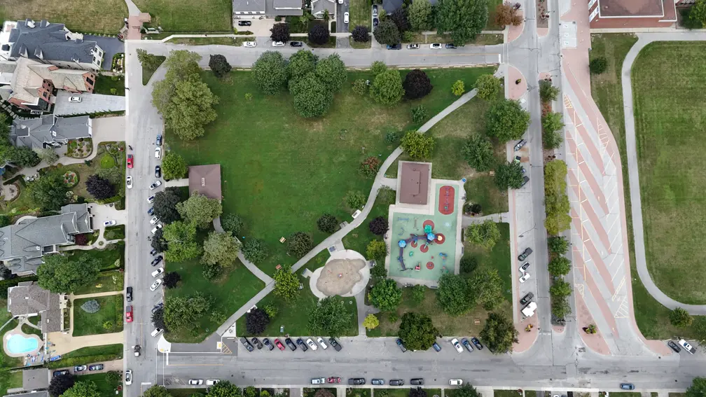 Aerial view of the park showing pavilion, playground, splashpad, washroom building, trails and trees.