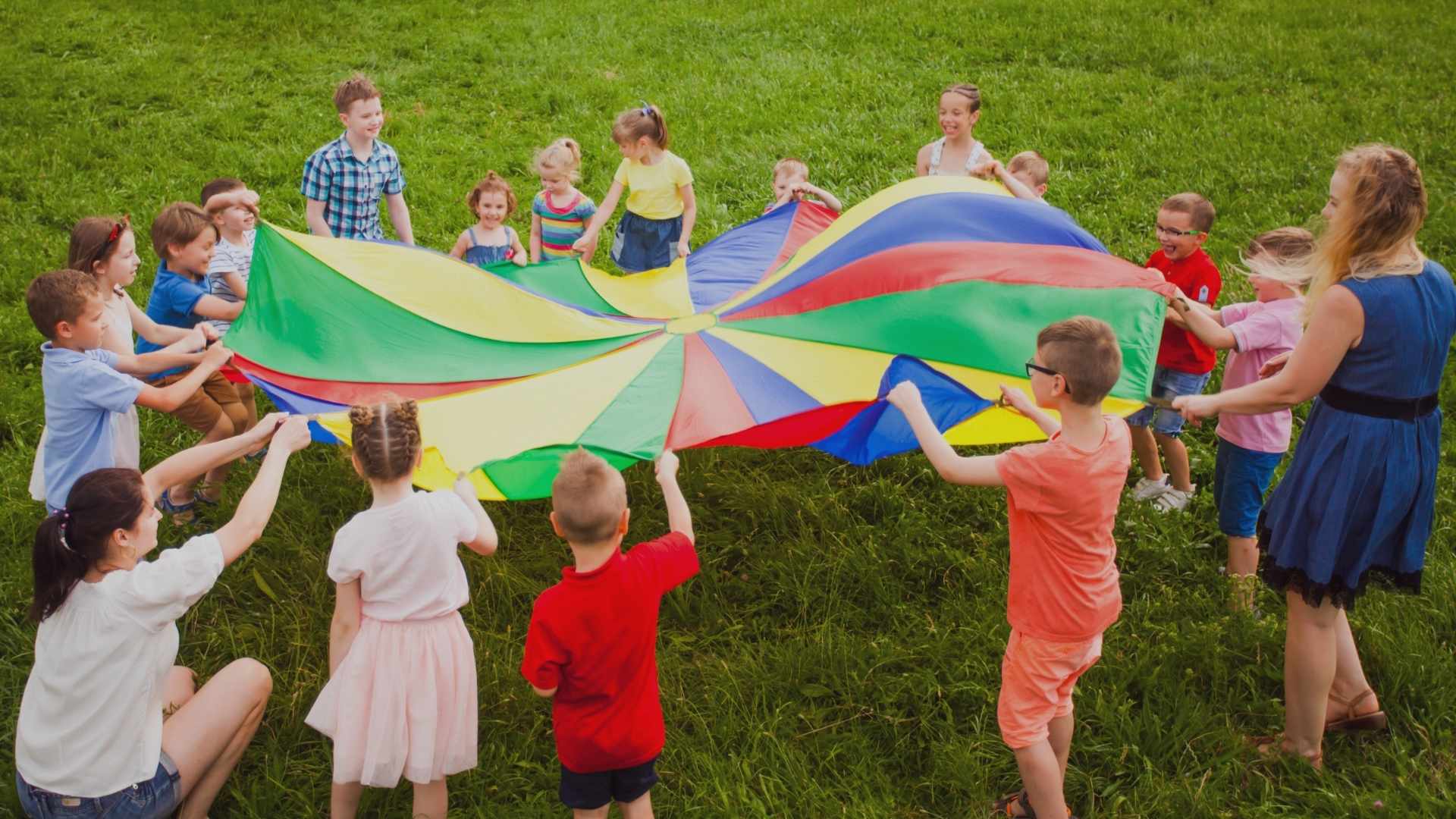Children and camp instructors playing the parachute game