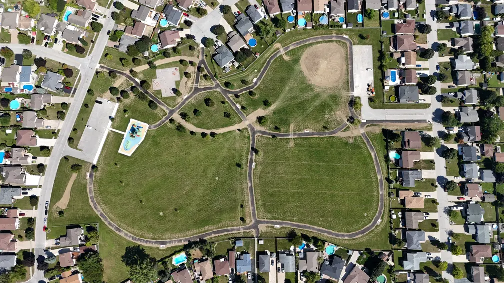 Aerial view of park showing playground, swing set, new hill and pathways