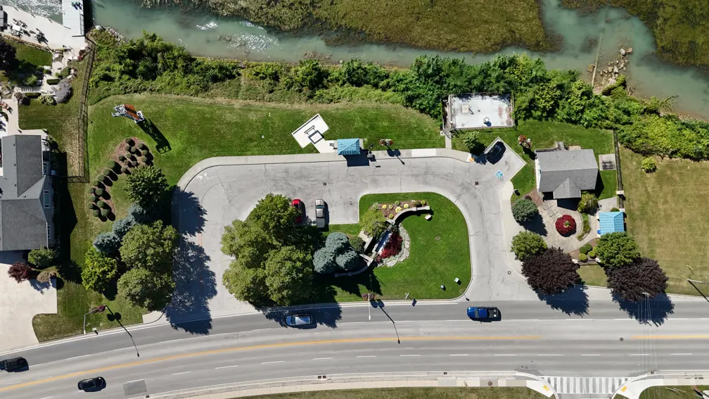 Aerial image of park including 'Hole in the Wall' selfie frame, tourism building, parking lot, covered bench and parking lot.