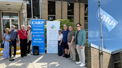 Members of Council, Amherstburg staff and the public pose in front of Town Hall to acknowledge Seniors Month in Ontario. The Canadian Association of Retired Persons flag flies above Town Hall