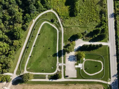 Aerial of Larry Bauer Dog parks, both the large and small showing trails around the park along with trees.