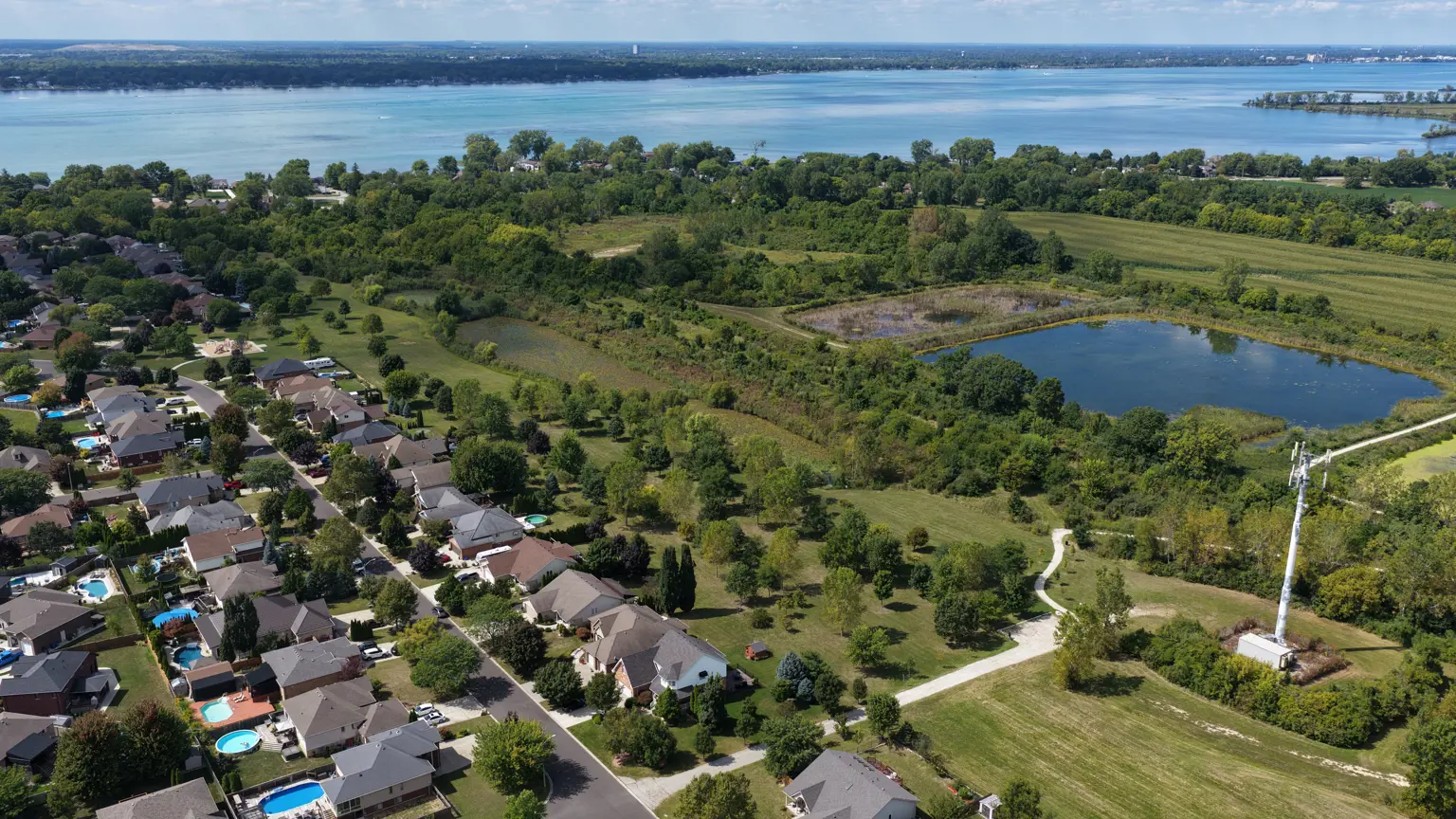 Aerial image of natural area behind the playground, showing large pond, trees and grassed area