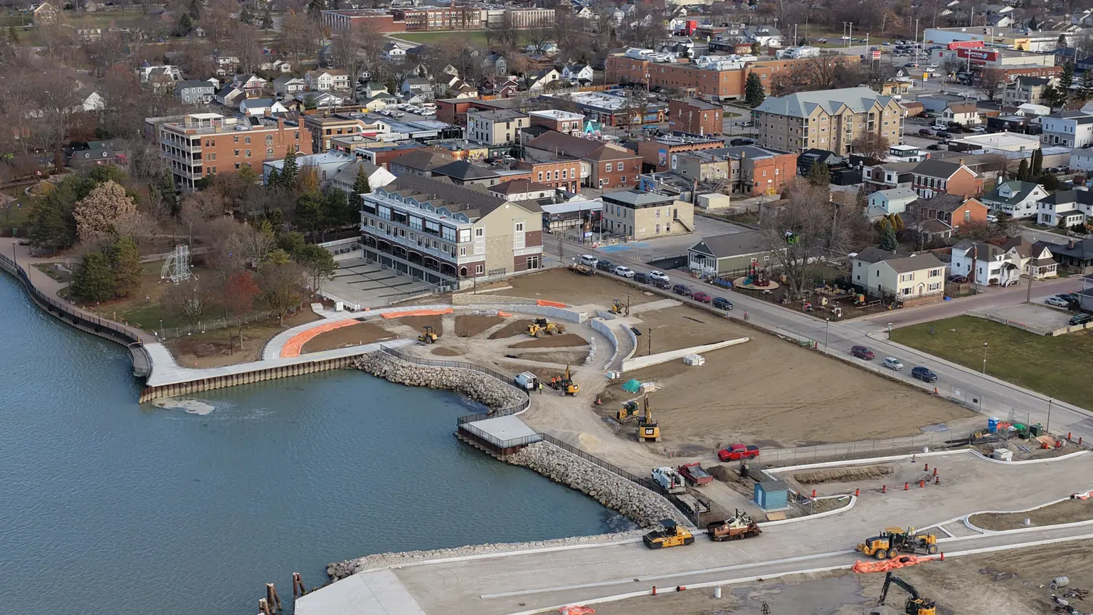 Aerial image of plaza showing waterfront, railings, green space and 'wheel with spokes' design in concrete and pathways.